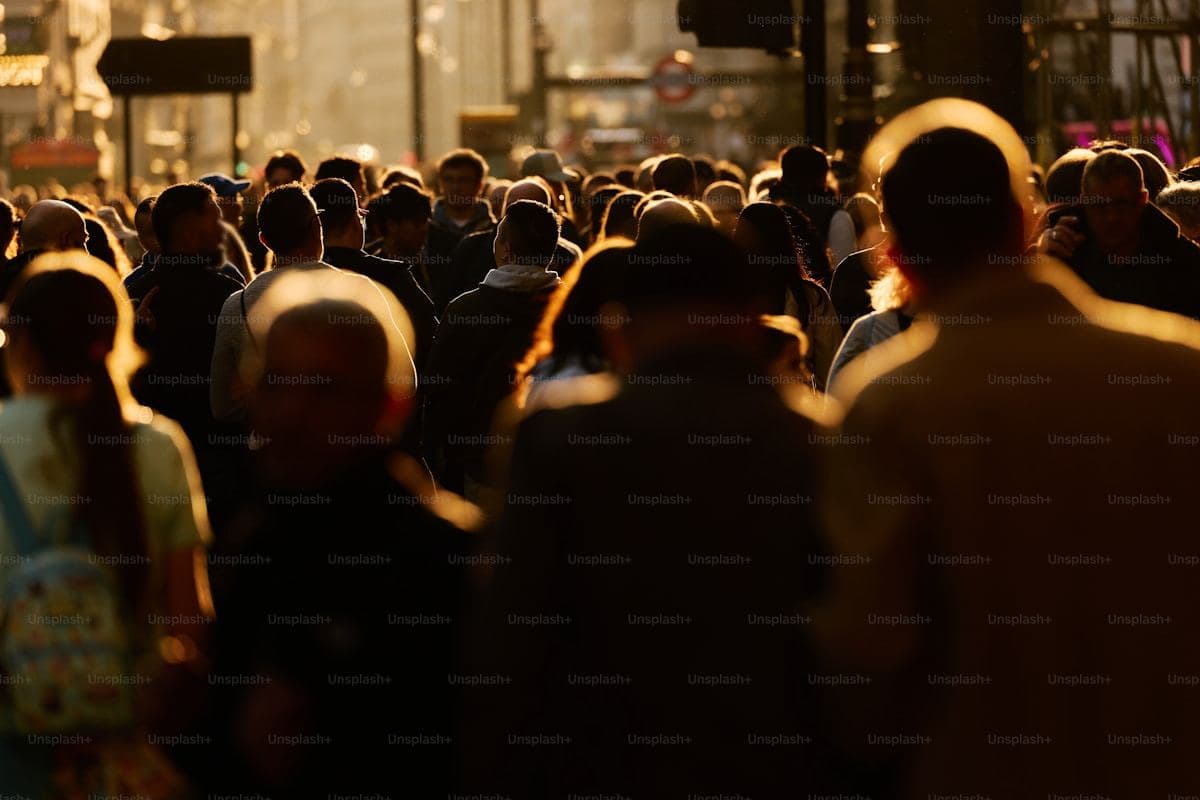 Crowd of people walking in sunlight